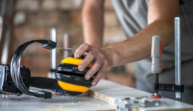 Closeup professional carpenter workplace with protective headphones.