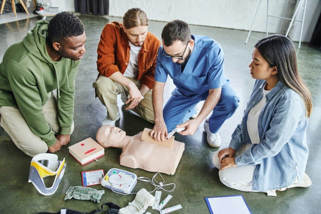 first aid seminar, high angle view of paramedic tamponing wound on simulator with bandage near