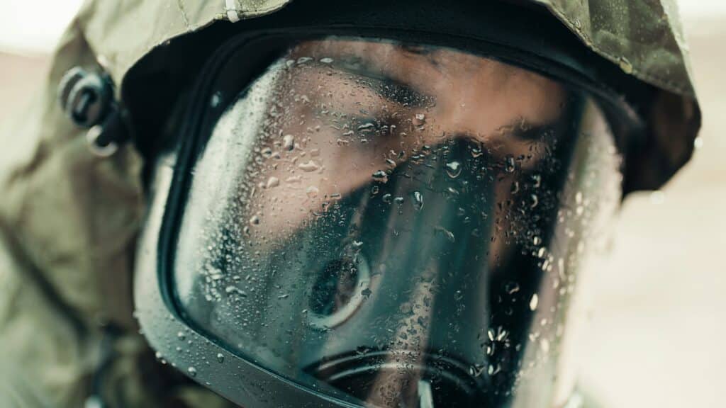 man with gas mask under the rain