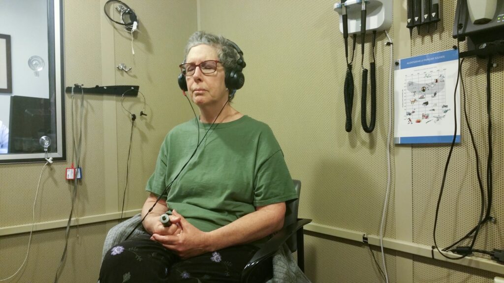 Hearing test in a soundproof room given using headphones and a signaling device the patient uses